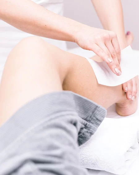 Professional leg waxing service for smooth skin by an expert technician at Divine Threading and Lash Beauty Studio.